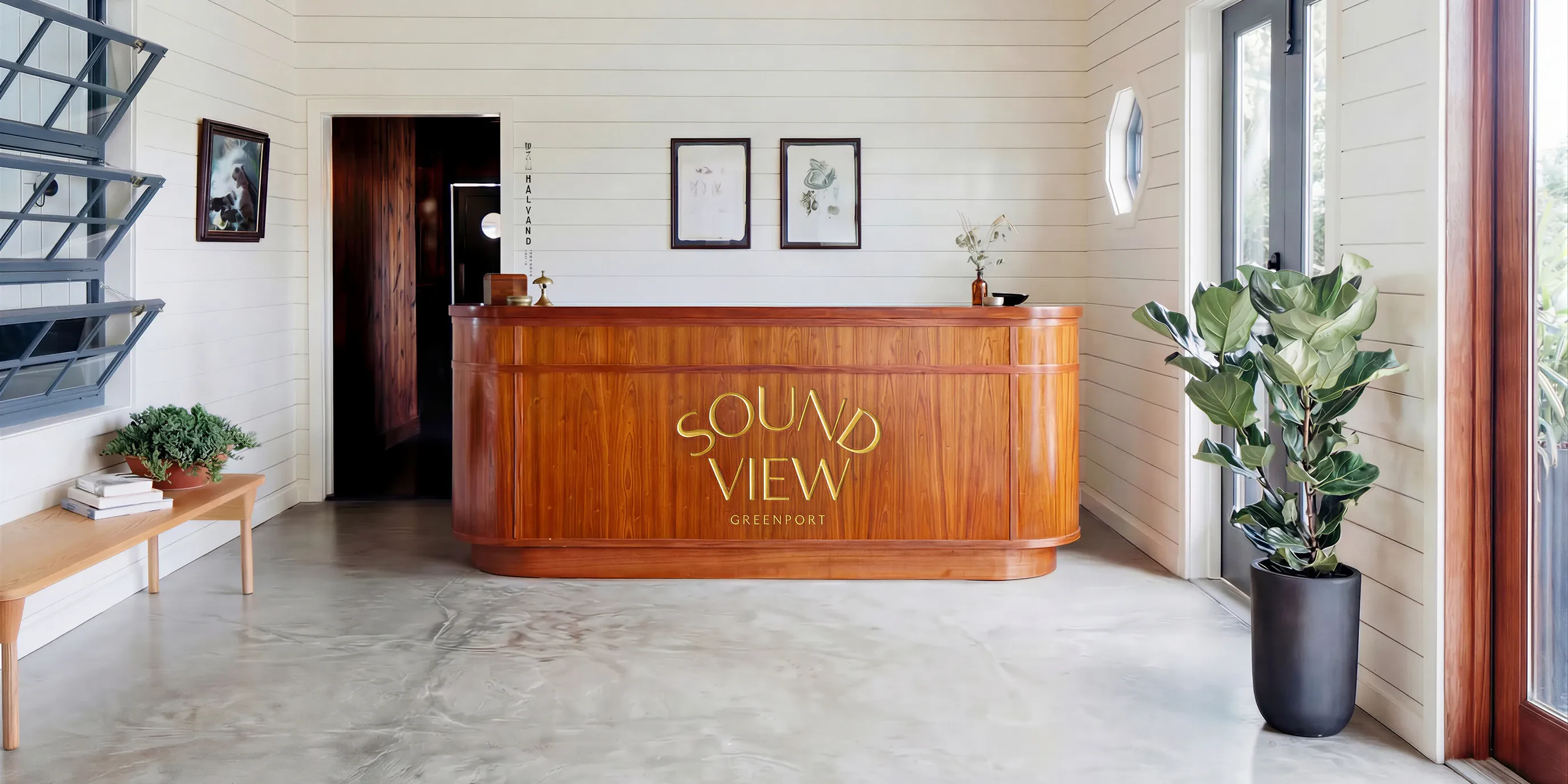 Sound View wood reception desk with gold lettering and potted fiddle-leaf fig