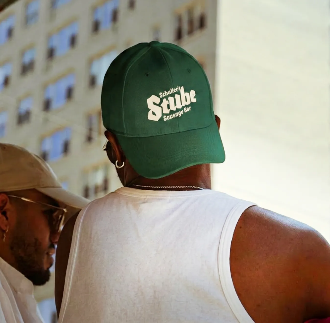 Man wearing a green Schaller's Stube Sausage Bar cap