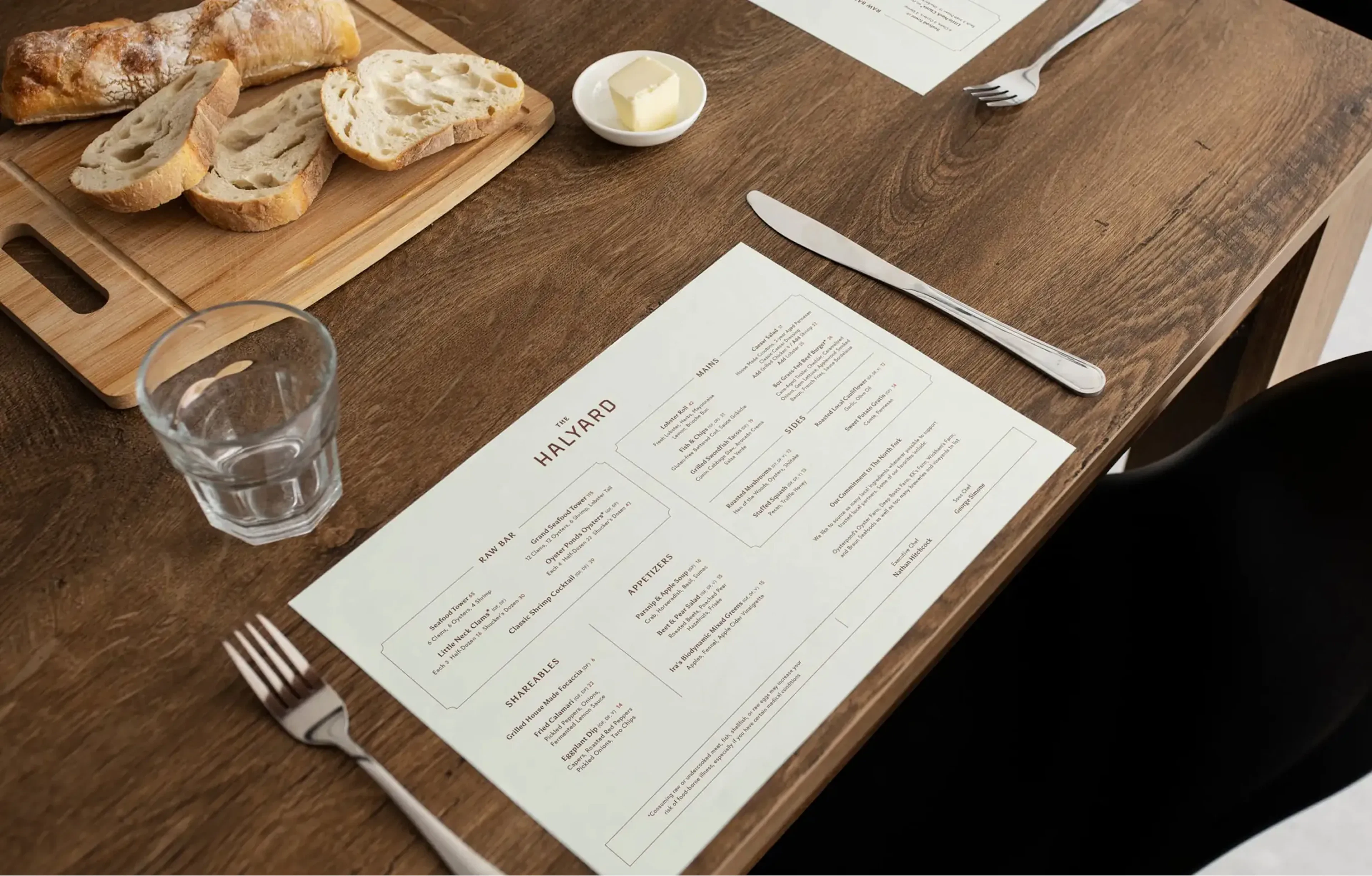 Halyard menu on wood table beside bread, butter, and cutlery