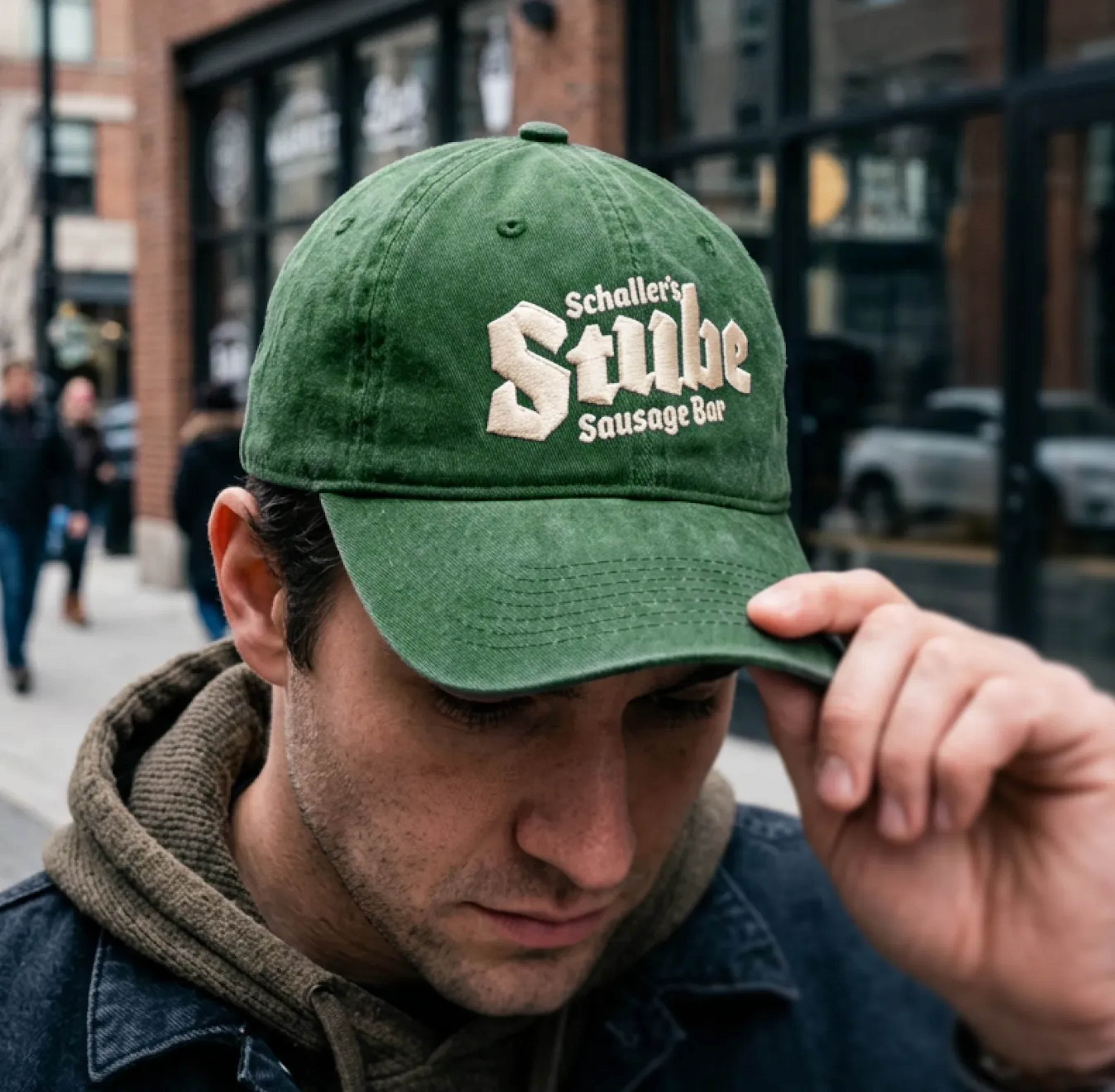 A man wearing a green ball cap with the Stube logo on the front.