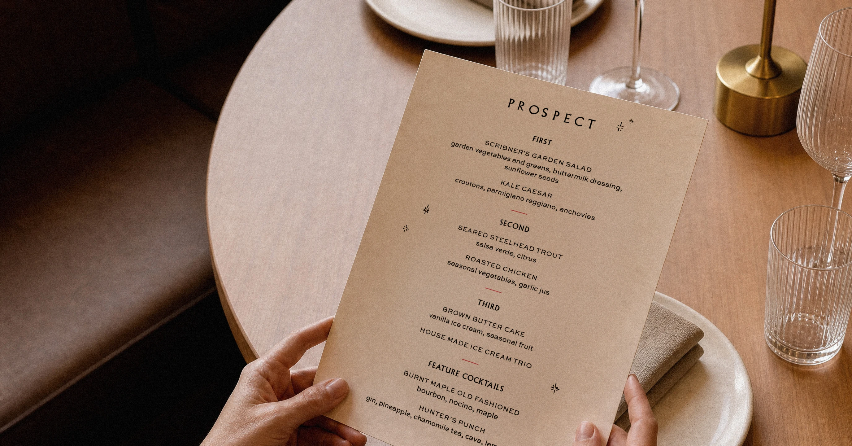 Prospect menu held over a restaurant table set with glassware