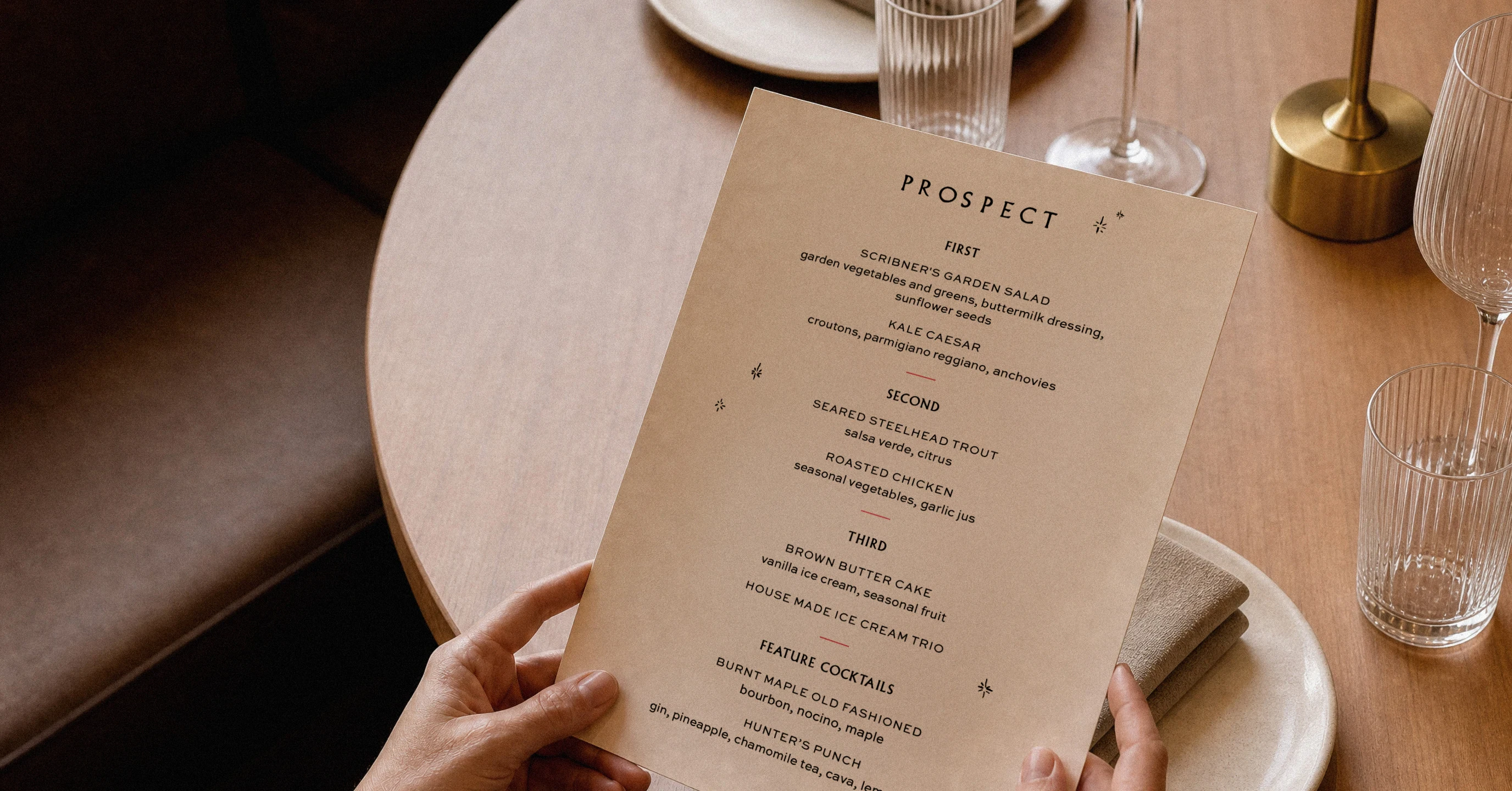 Prospect menu held over a restaurant table set with glassware