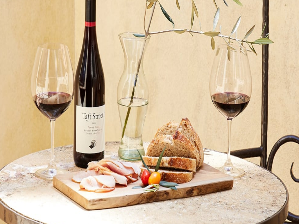 Wine, bread and charcuterie on outdoor table