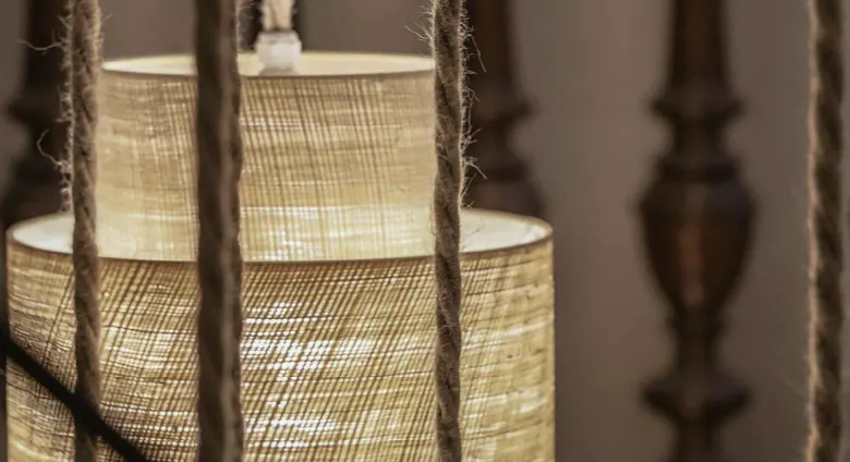 Détail suspension luminaire, avec garde de corps en bois en second plan.