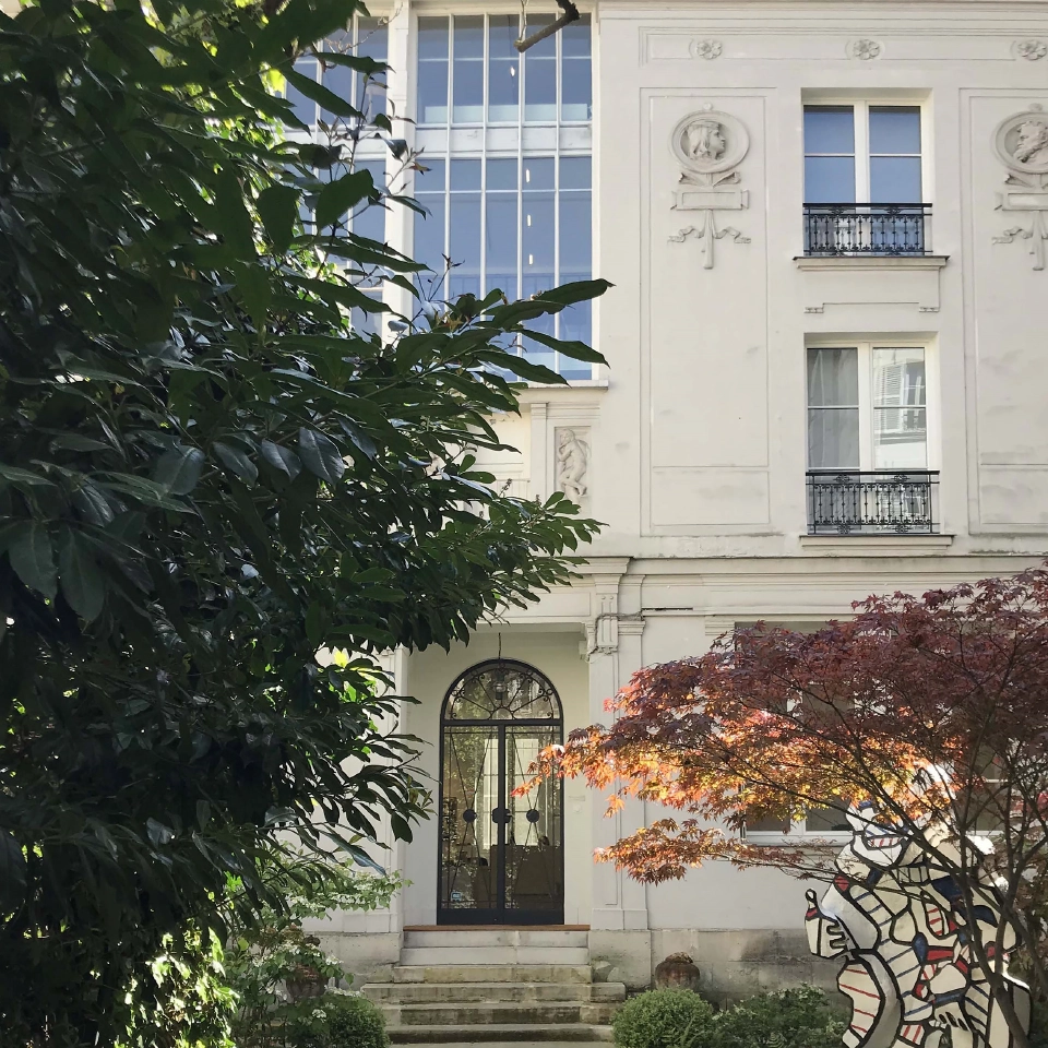 Façade de la fondation Dubuffet, arbres au premier plan avec sculpture.