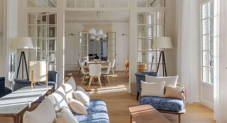 Hôtel, vue intérieur sur salon avec cheminée en premier plan et canapé.