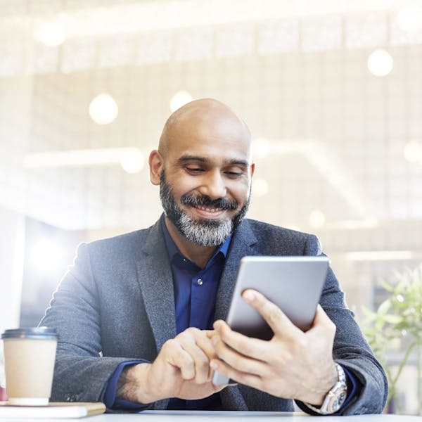 Homme avec une tablette dans un café