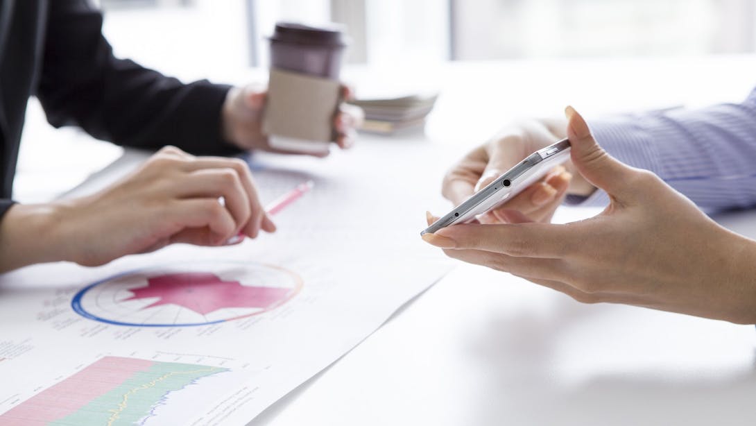 Donna che mostra a collega cellulare