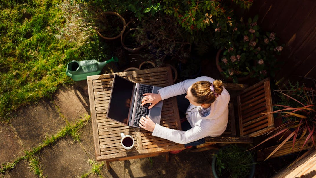 Donna in giardino che digita sul computer