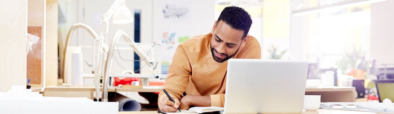 Uomo che scrive appunti davanti al pc Uomo che scrive appunti davanti al pc