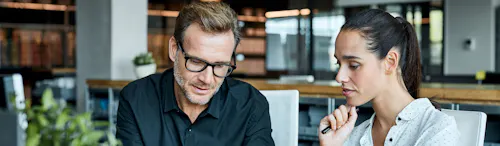 uomo e donna seduti dietro una scrivania uomo e donna seduti dietro una scrivania