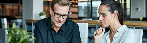 uomo e donna seduti dietro una scrivania uomo e donna seduti dietro una scrivania