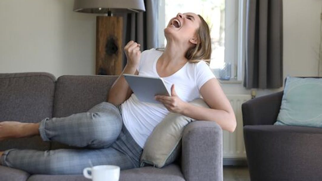 Ragazza che esulta sul divano