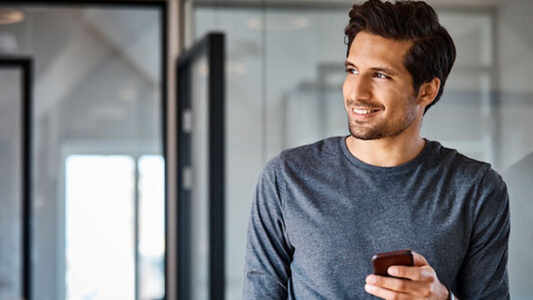 Homme souriant avec un smartphone