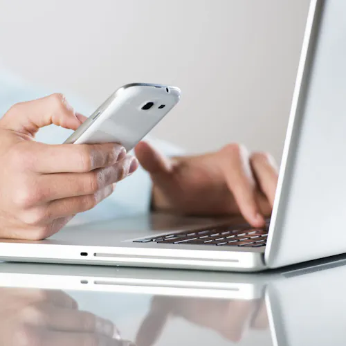 uomo con computer acceso e cellulare in mano uomo con computer acceso e cellulare in mano