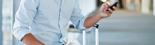 uomo seduto all'aeroporto con cellulare in mano uomo seduto all'aeroporto con cellulare in mano