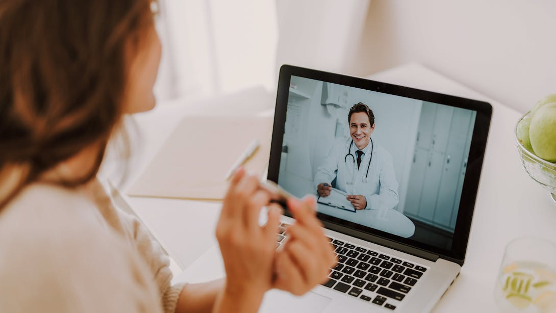 Femme en téléconsultation avec un médecin en blouse blanche