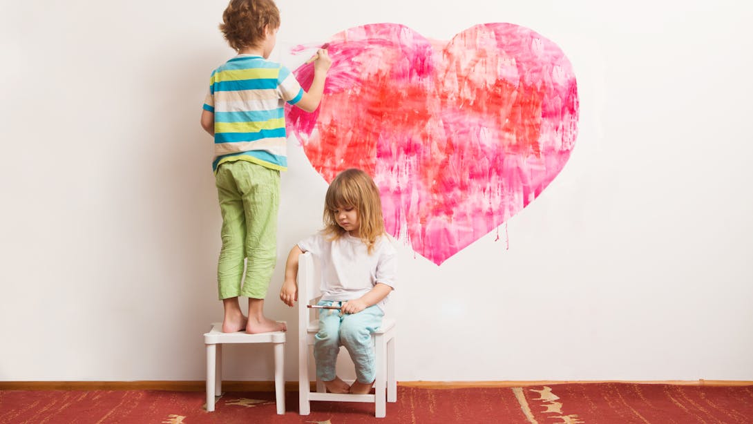 Bambini che disegnano cuore sul muro