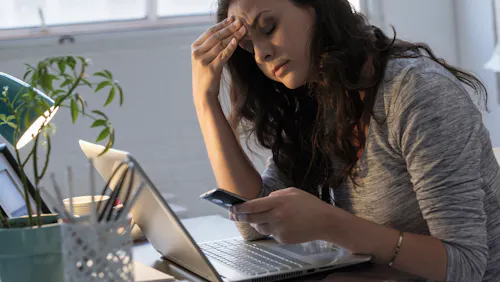 donna al cellulare seduta davanti alla scrivania donna al cellulare seduta davanti alla scrivania