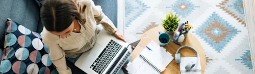 donna che scrive su agenda seduta sul divano donna che scrive su agenda seduta sul divano