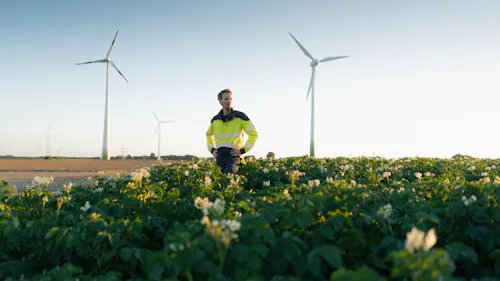 homme dans les champs avec éoliennes en fond homme dans les champs avec éoliennes en fond