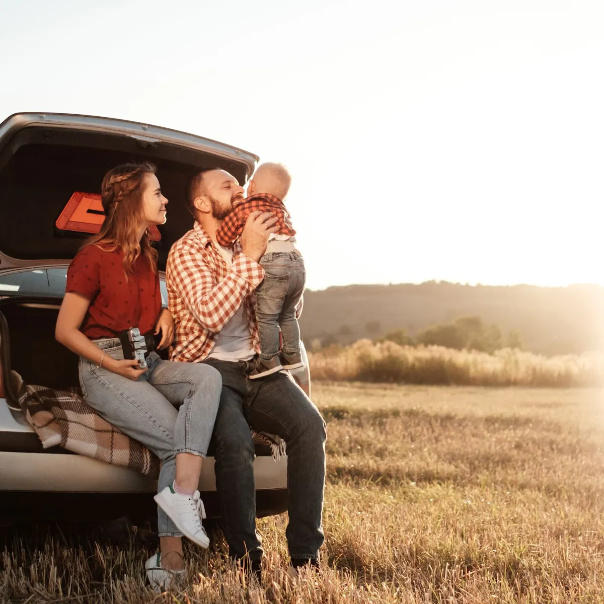famiglia seduta nel cofano posteriore della propria auto