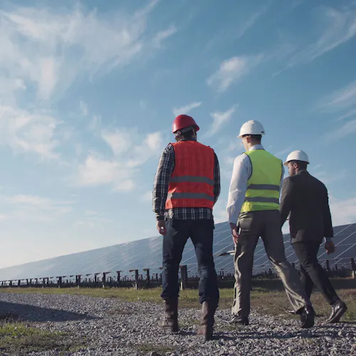 men in solar panel field men in solar panel field