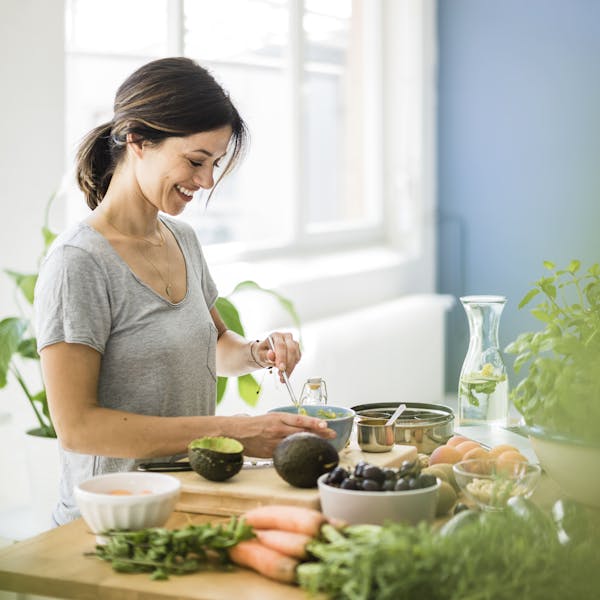 Femme qui déjeune d'un repas riche en légumes