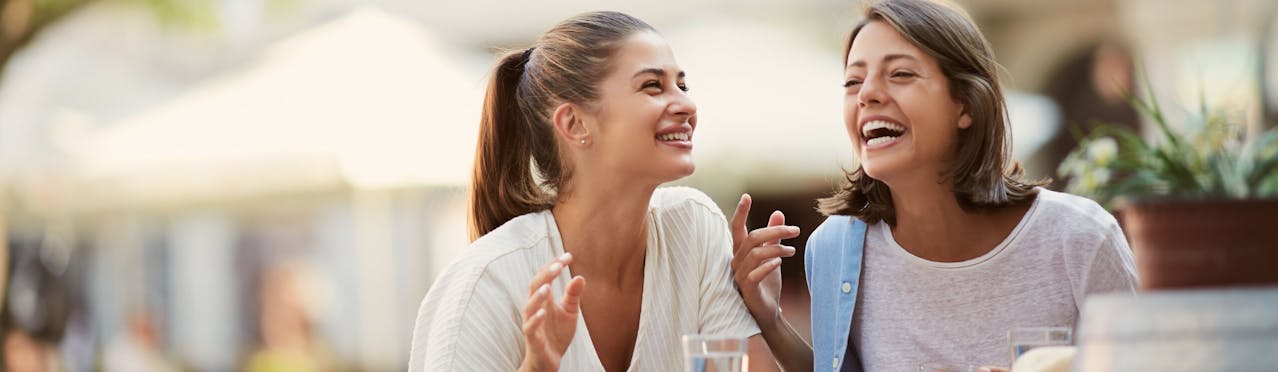 Ragazze che ridono sedute in una bar