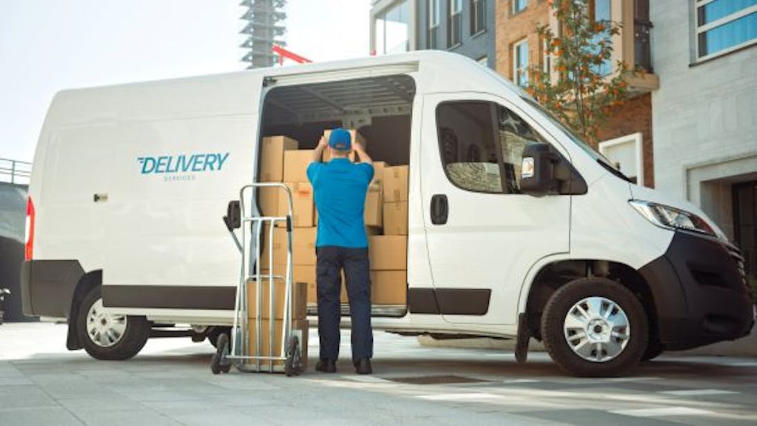 A delivery driver carries parcels in his commercial vehicle