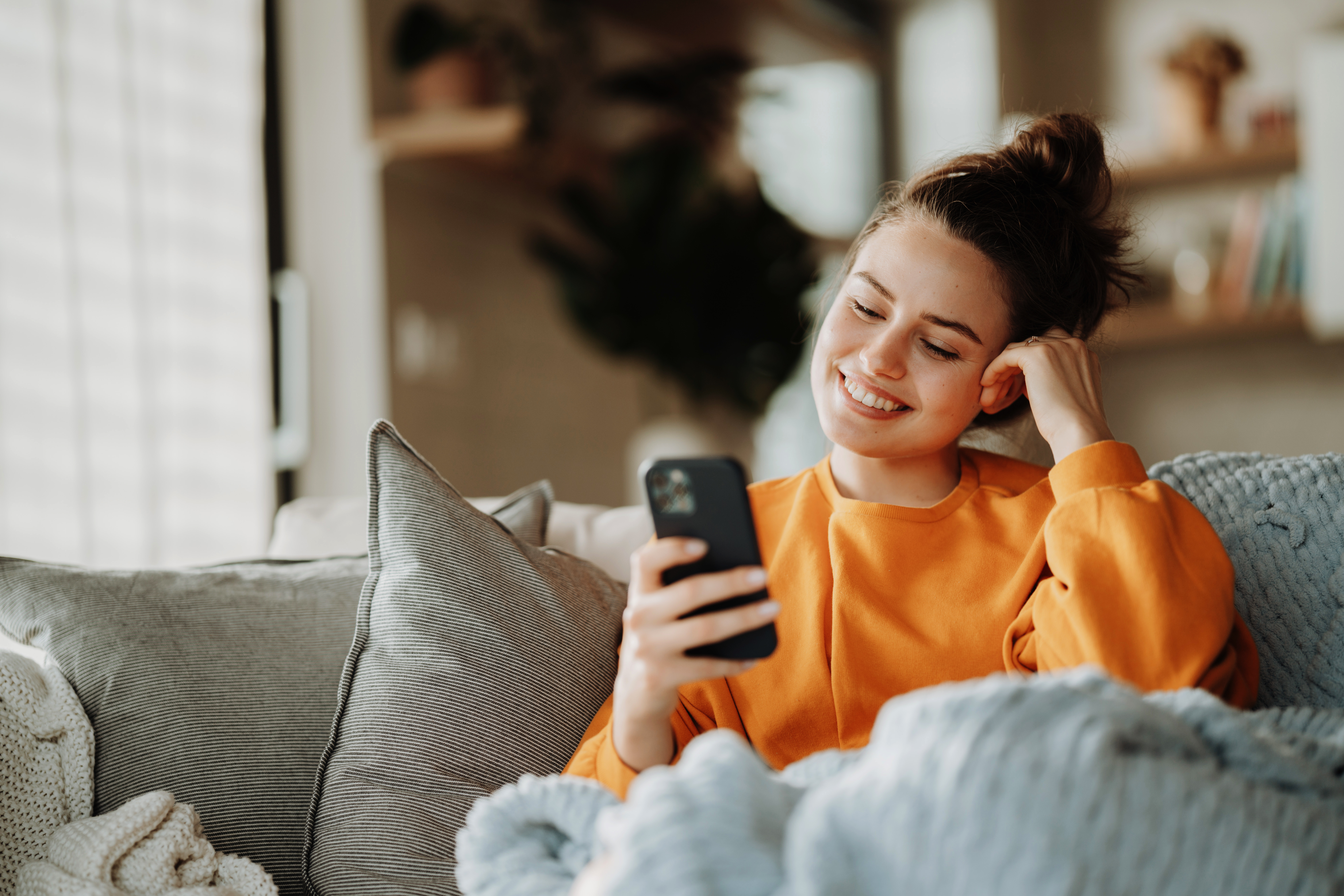 Young smiling girl looking at her smartphone