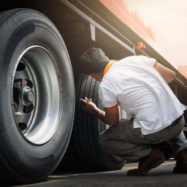 A breakdown mechanic changes a lorry wheel