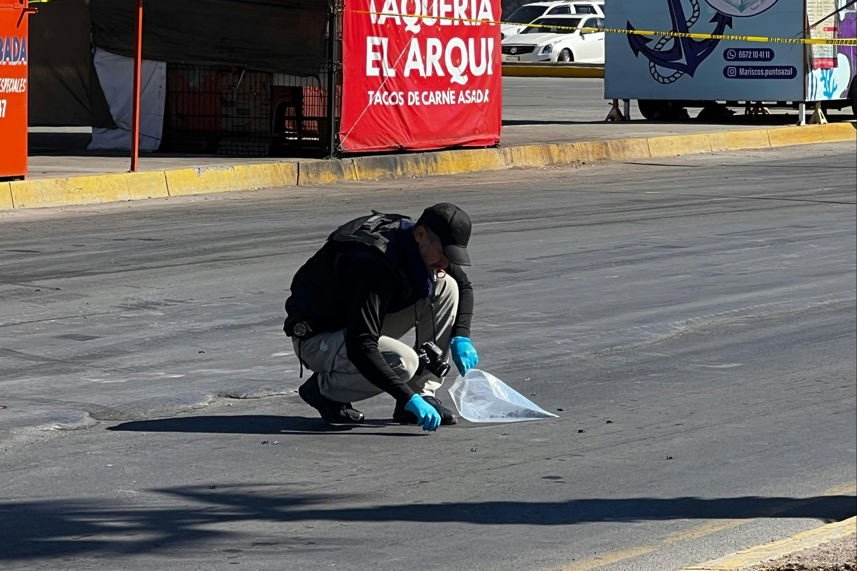 Un perito recoge casquillos regados tras el atentado a agentes de la FGE. Foto Jesús Verdugo.