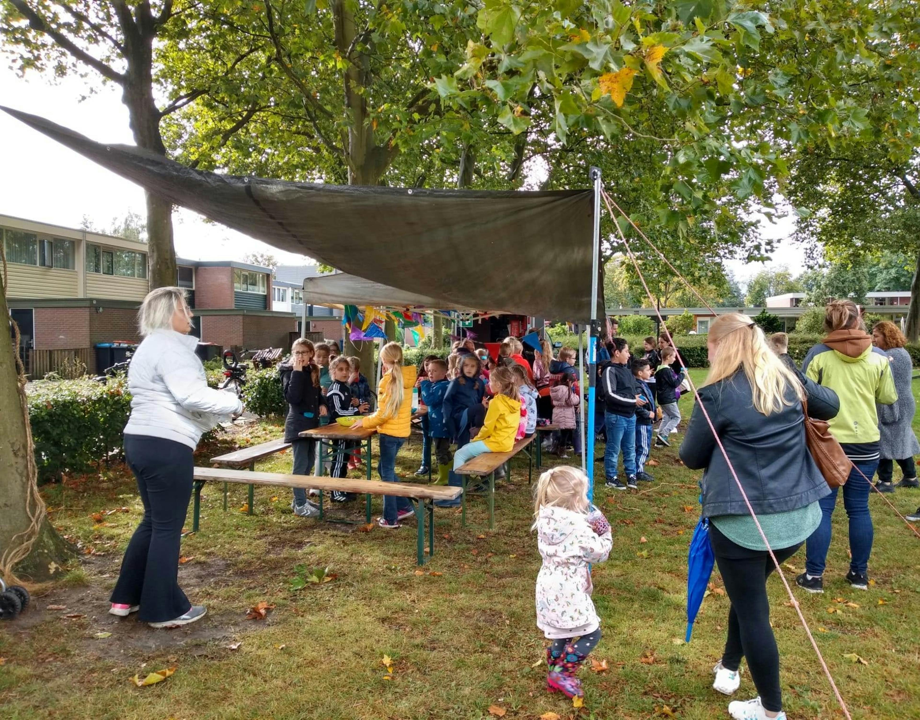 tent met mensen eronder op het veld.