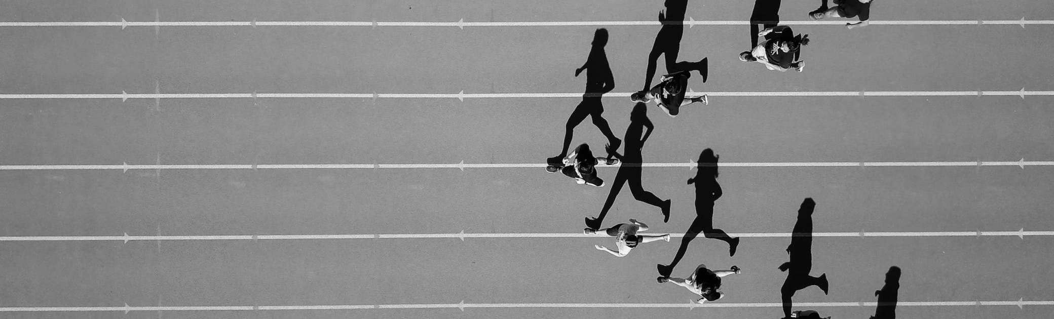 Overhead view of a heat of sprinters running on a track in v-formation