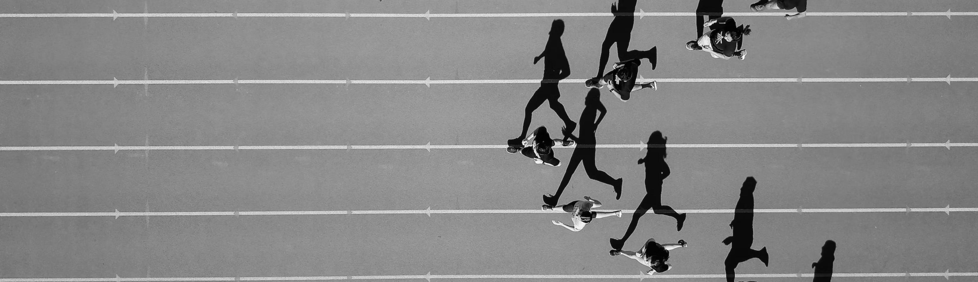 Overhead view of a heat of sprinters running on a track in v-formation