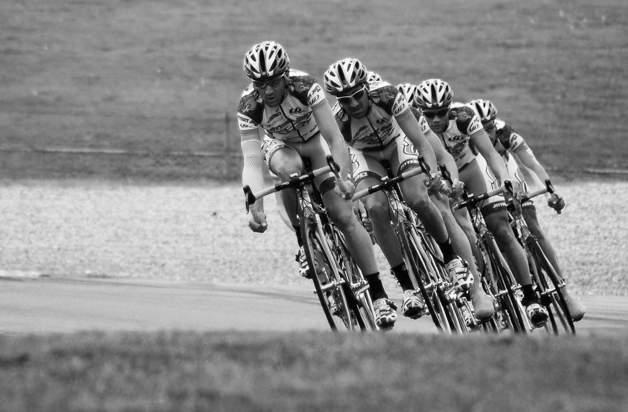 A relay race runner sets at a track starting block while holding a baton