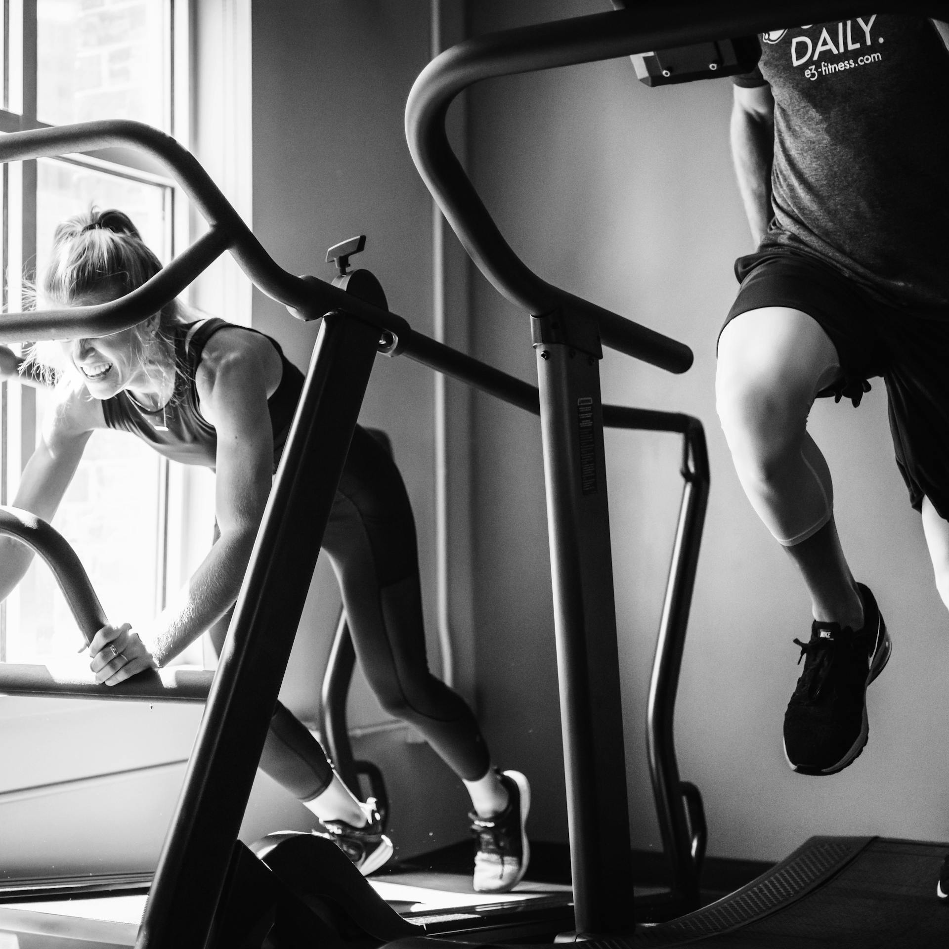 Two gym members run on treadmills at a fitness centre