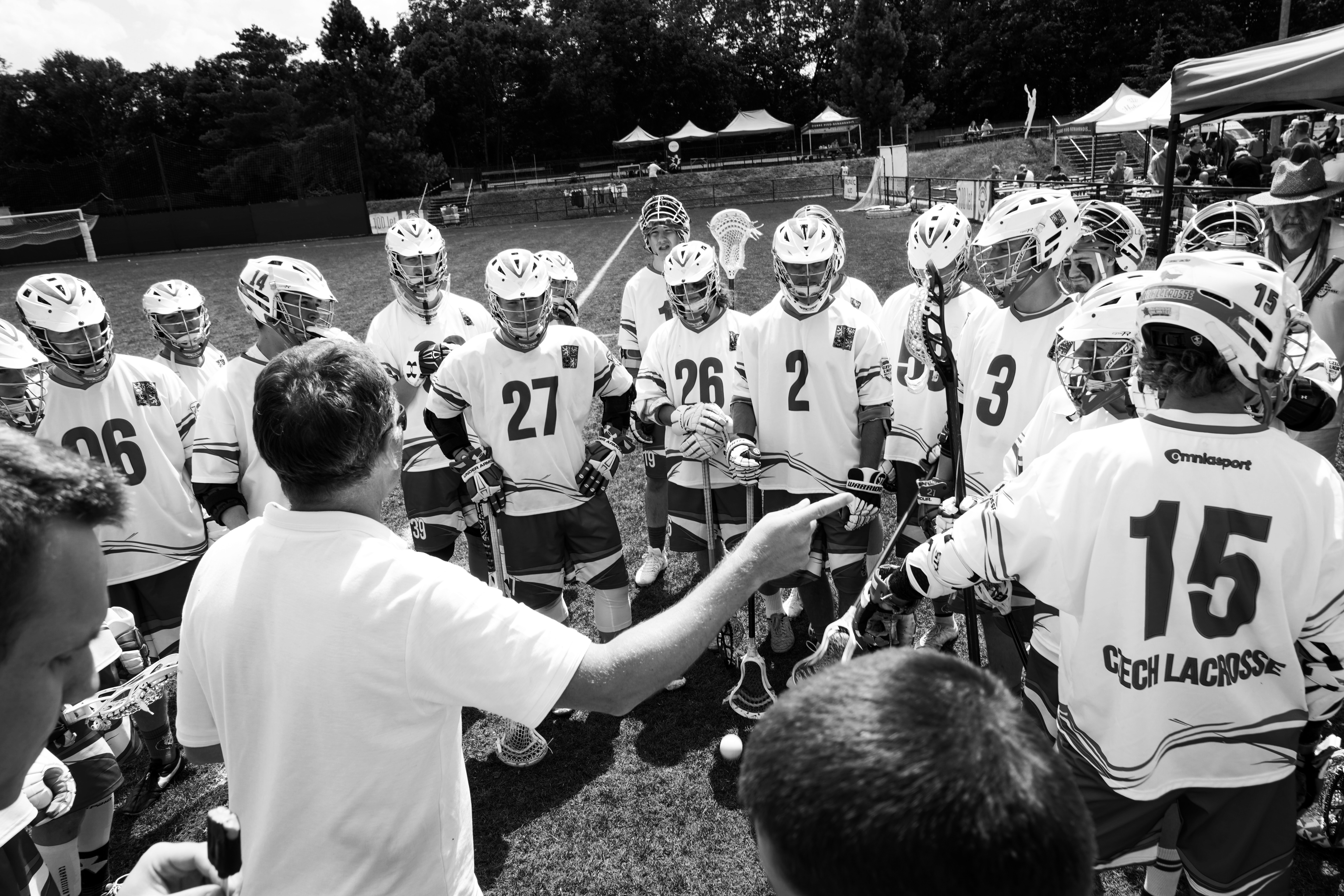 Coach managing his lacrosse team members on the playing field sidelines