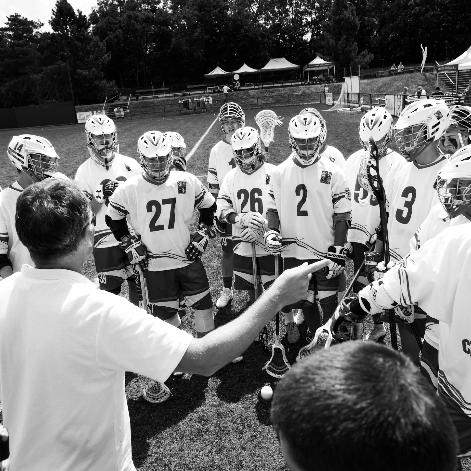 Coach managing his lacrosse team members on the playing field sidelines