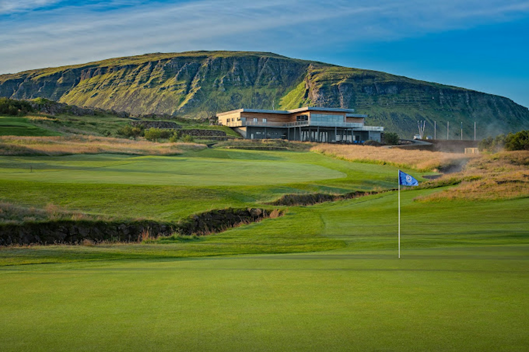 Community golf course with green and flag in scenic countryside location for sports programmes