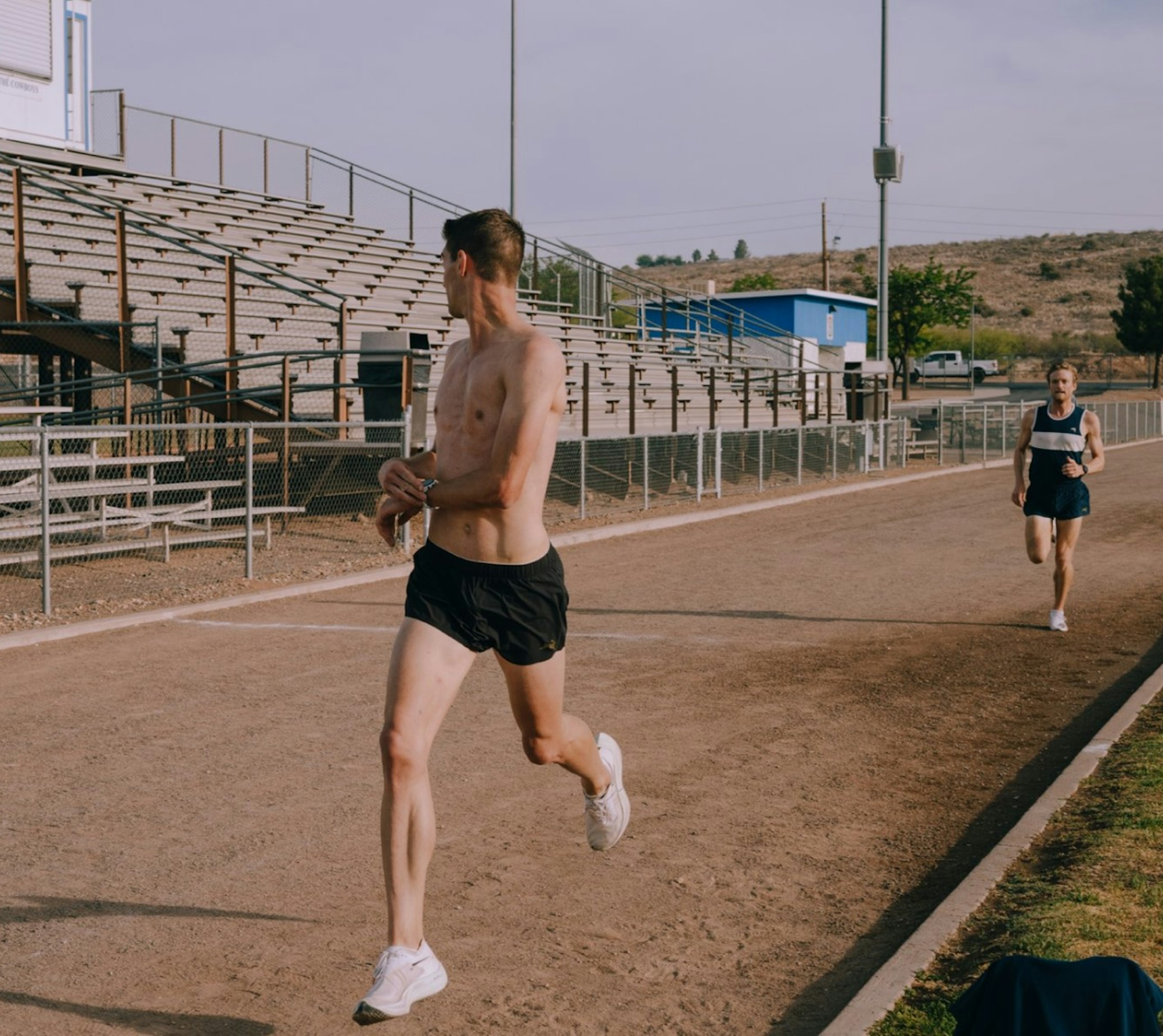 Male athlete running on outdoor sports track at community athletics facility