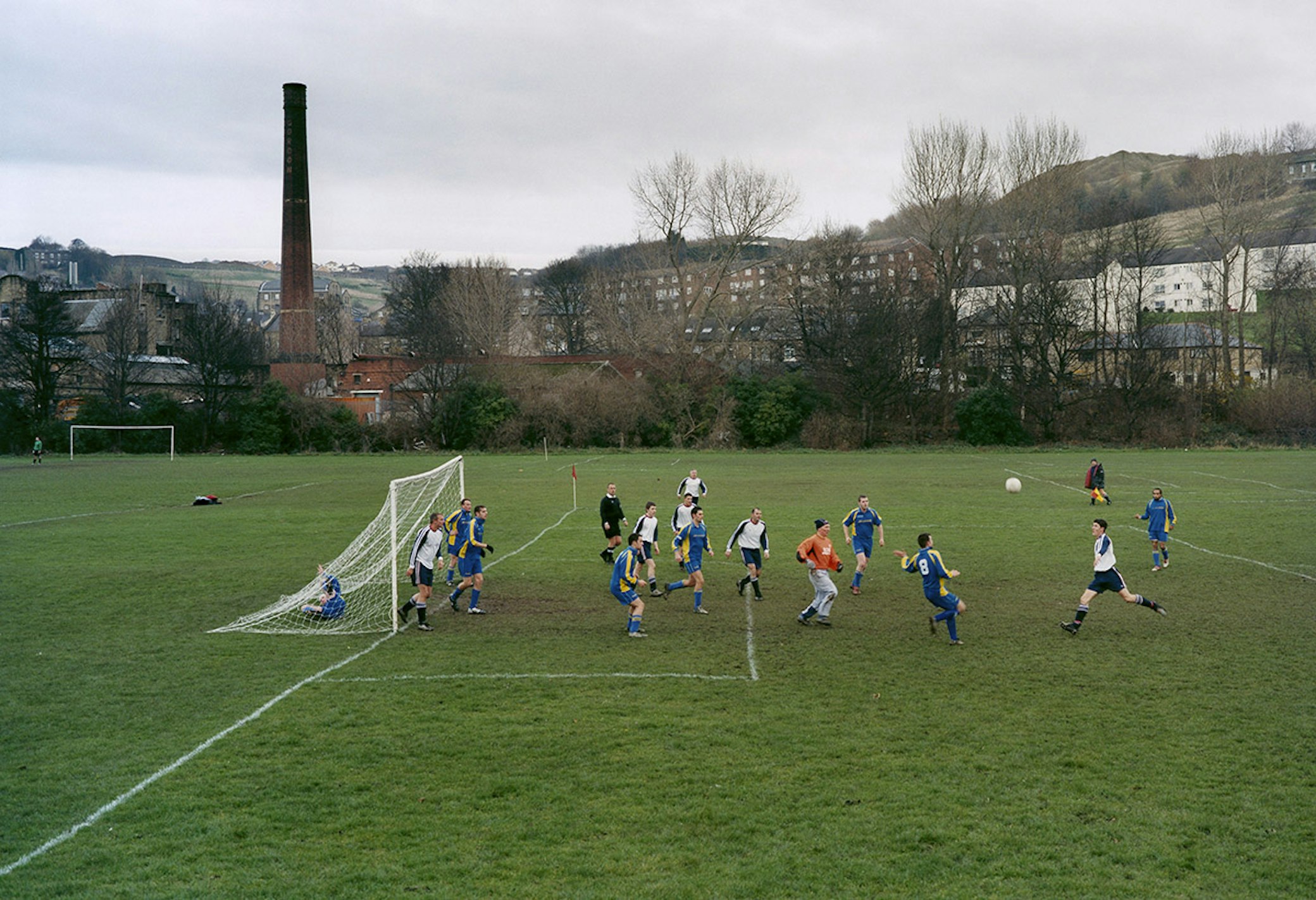 Youth football training session on community sports pitch with children practicing skills in organised drills