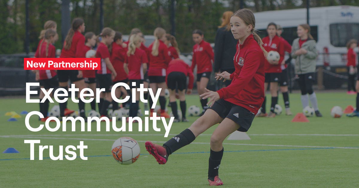 Young girl kicking a soccer ball at Exeter City Community Trust event.
