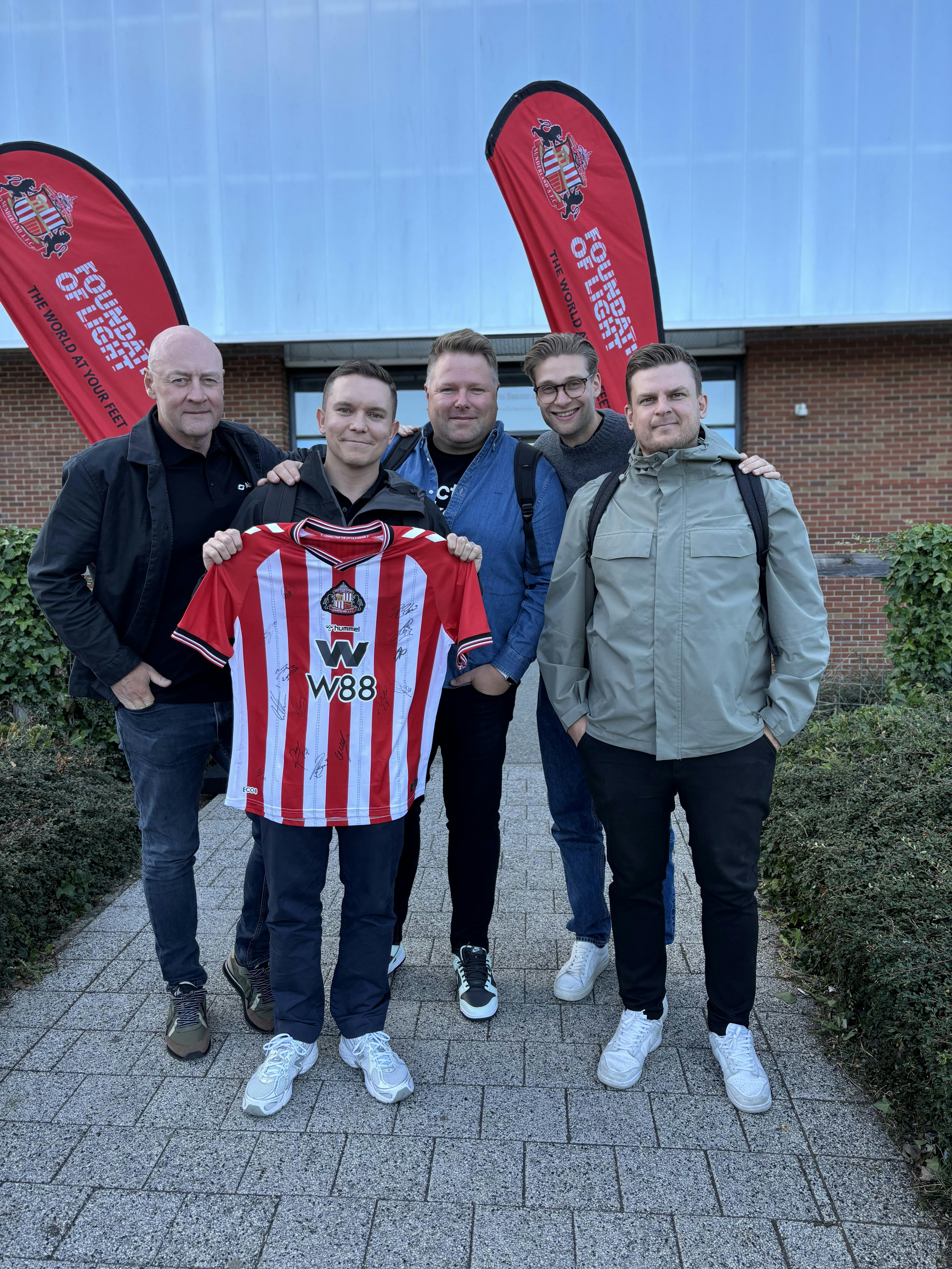 The Abler team holding a Sunderland jersey