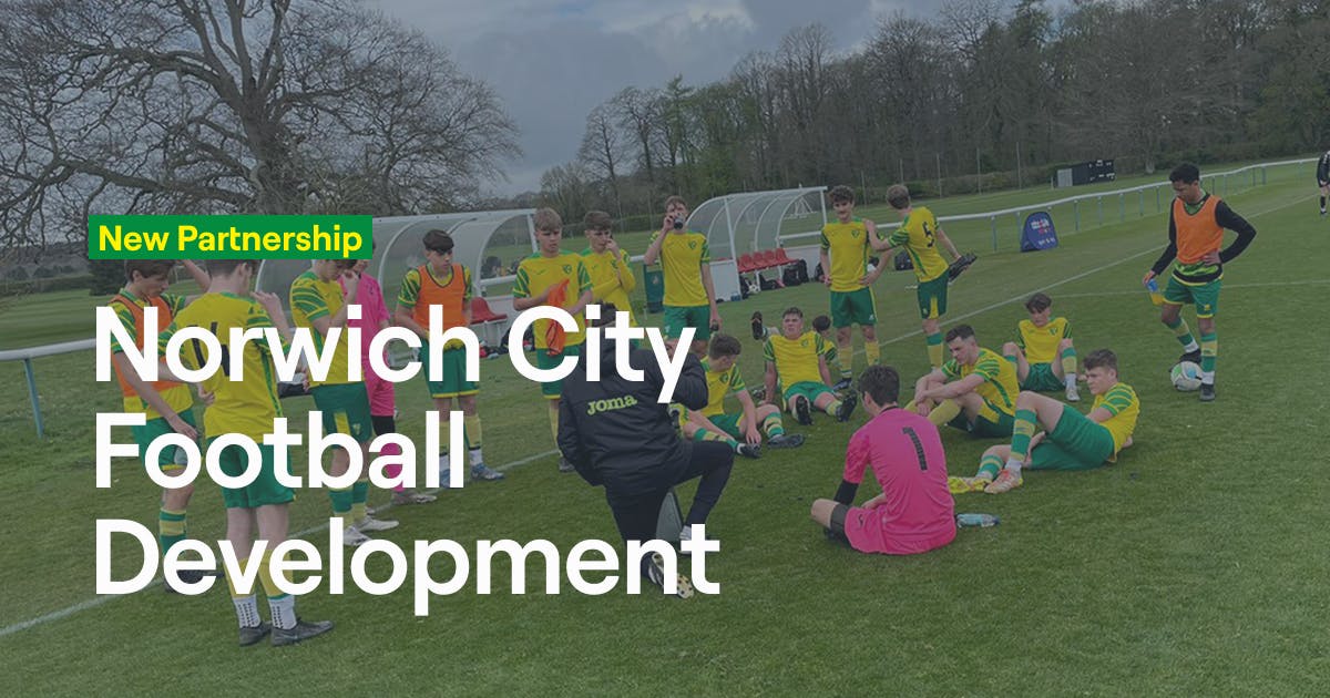Young football players in Norwich City yellow and green kits sitting on grass listening to a coach during a training session, with "New Partnership Norwich City Football Development" text overlay announcing Abler's collaboration with the academy.