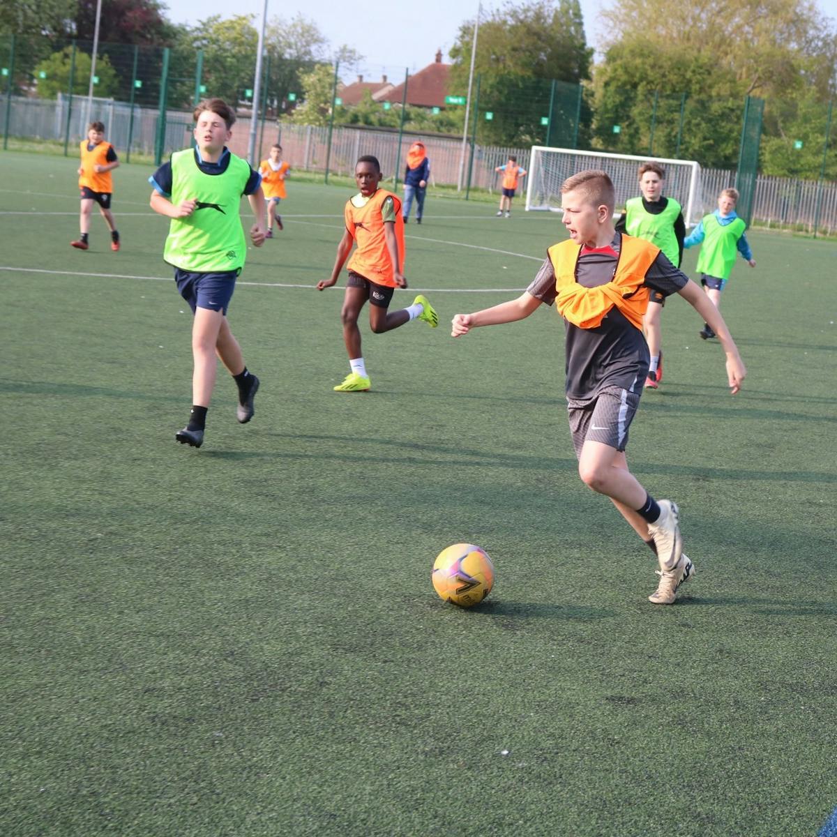 Children playing football on community pitch as part of Tigers Trust youth development programme in Hull and East Yorkshire