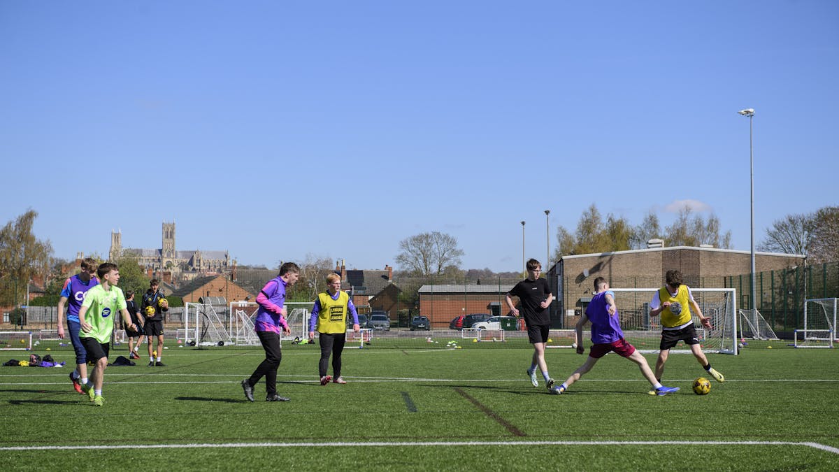 oung footballers in Lincoln City kit showcase the technical skills learned through the Foundation's coaching programmes. Close-up training sessions like these help develop ball control, decision-making, and game awareness in a supportive, age-appropriate environment.