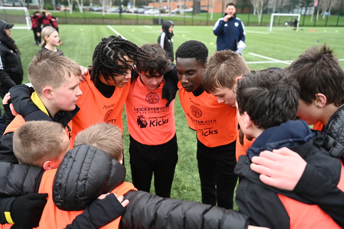 Young participants in Leicester City Community Trust's Premier League Kicks programme building teamwork and community connections through football.