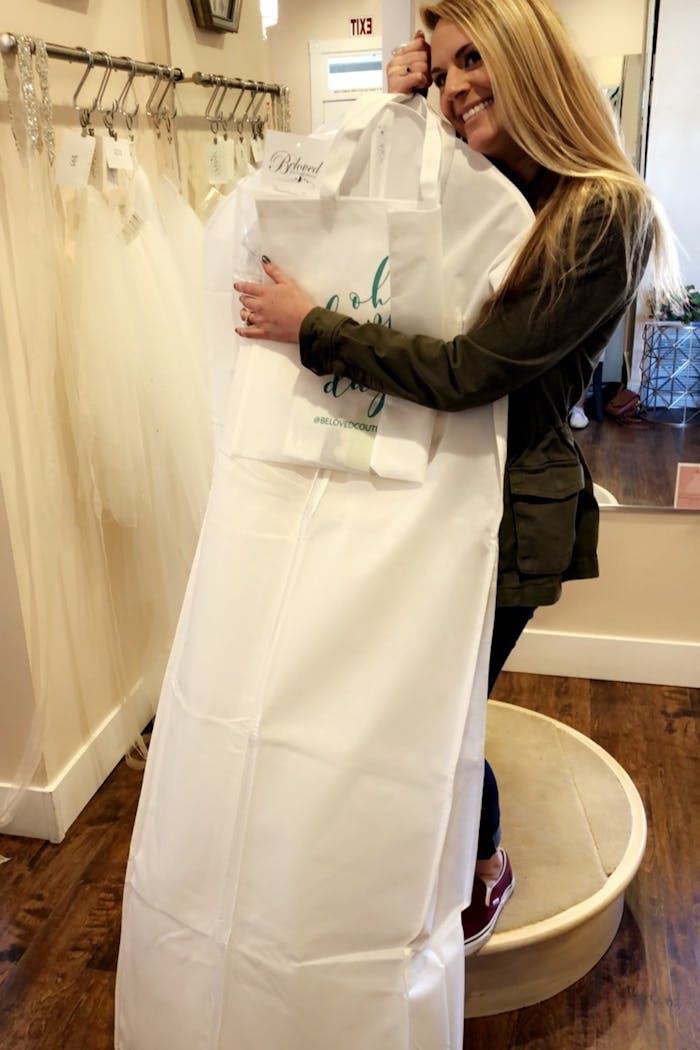 Niko hugging her bagged wedding dress from Beloved Couture Bridal